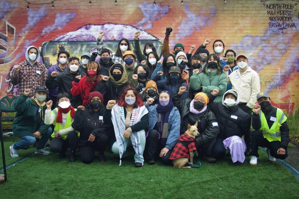 Image Description: a group of transgender & queer APIs gather with fists raised.