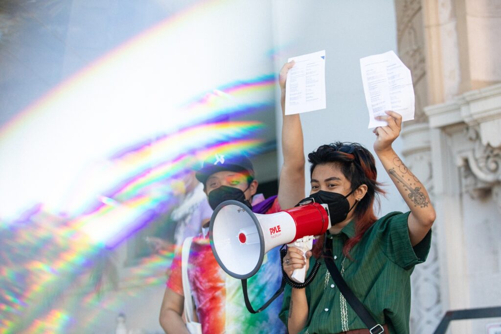Image description: two LavNix members chant “Care Not Cops!” into megaphones together.